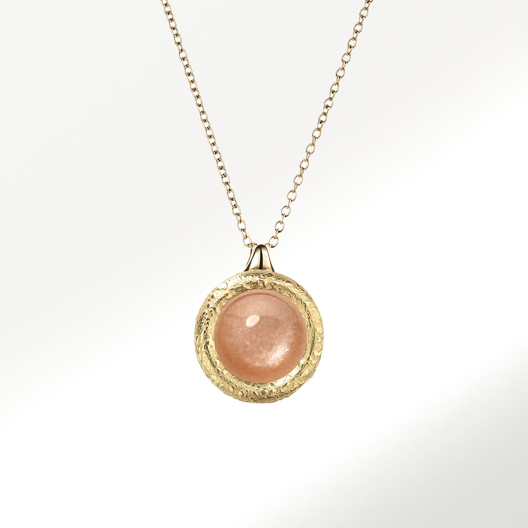 Collar Elena Carrera colección Fusión en oro de 18 quilates (750 milésimas), botón de 9mm con adularia peach natural, talla cabuchón sobre fondo de madreperla. Perfecto para disfrutarlo con todos tus estilismos. BY ELENA CARRERA