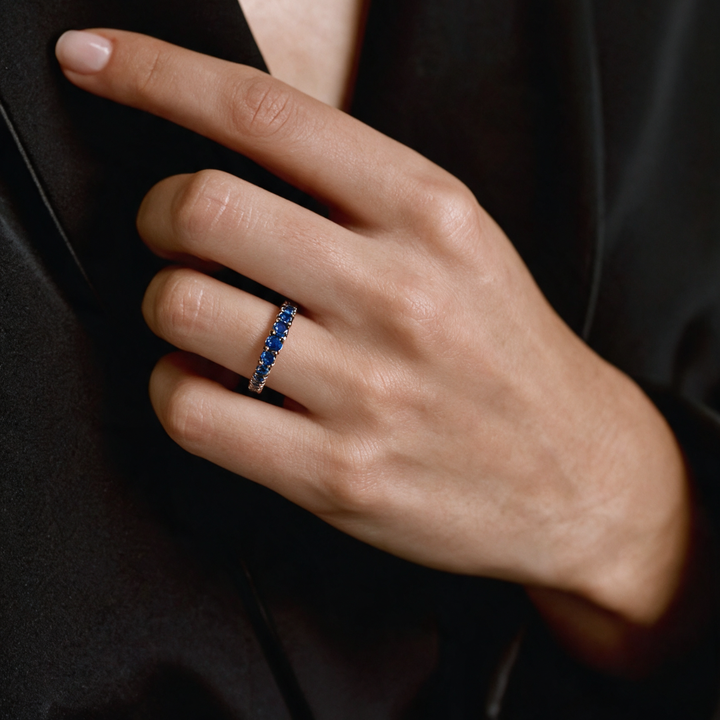 Alianza de zafiros azules en oro blanco 18k puesta en la mano