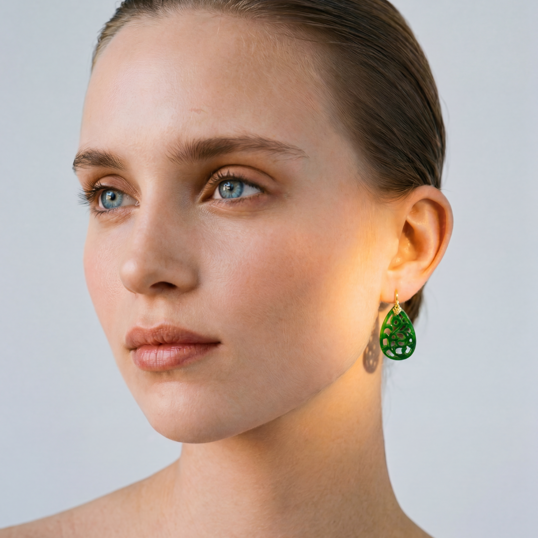 Modelo llevando pendientes de jade natural tallado en celosía con oro amarillo 18k