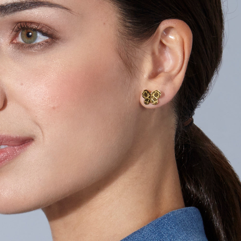 Modelo llevando pendientes Mariposa Grandes de By Elena Carrera en oro amarillo 18k con acabado textura coco
